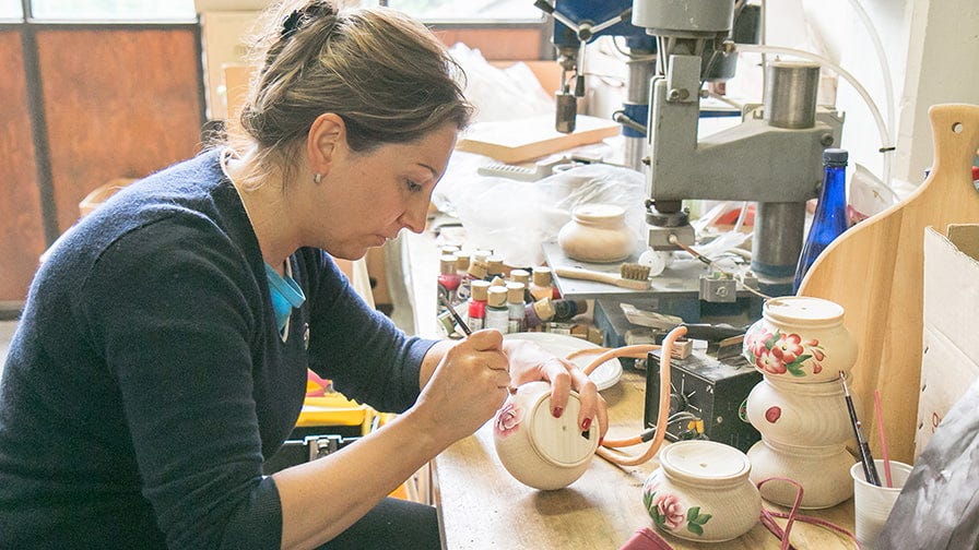 Noris paints the bowls by hand